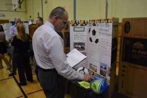 Even Evesham Township School District Superintendent John Scavelli Jr. got in on the judging action during the fair. Pictured is Scavelli as he examines one student’s experiment on how soccer balls inflated with different levels of air would travel differently when kicked.