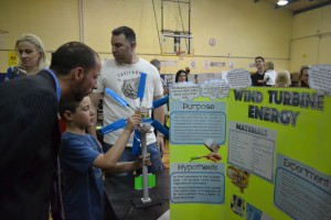 Payton Ogen, a 10-year-old fourth grader, used different wind turbine with different blade lengths and pitch factors to measure what the differences in energy output were. Pictured is Payton explaining his project to Evans principal Nick DiBlasi. 