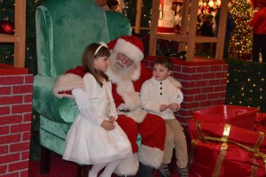 Callie and Donny Ferguson whisper to Santa in between taking holiday pictures at the Voorhees Town Center on Nov. 14 during Santa’s Granting Wishes Tree Lighting and Promenade Event. Santa arrived on a fire truck and helped light the tree outdoors before taking pictures inside with the children.