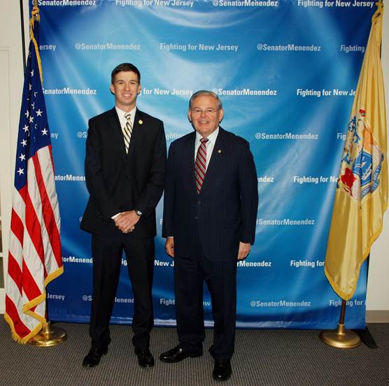 Russell Bauer III and Sen. Bob Menendez pose for a photo at a reception ceremony.