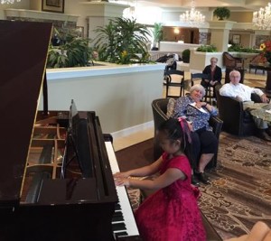 Ika Zhang, 6, performs on piano for seniors at Spring Hills Cherry Hill Assisted Living