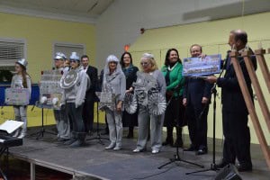 Cherry Hill Mayor Chuck Cahn (far right) introduces Cherry Hill Opoly to the guests in attendance as residents dressed as the games’ tokens take the stage.